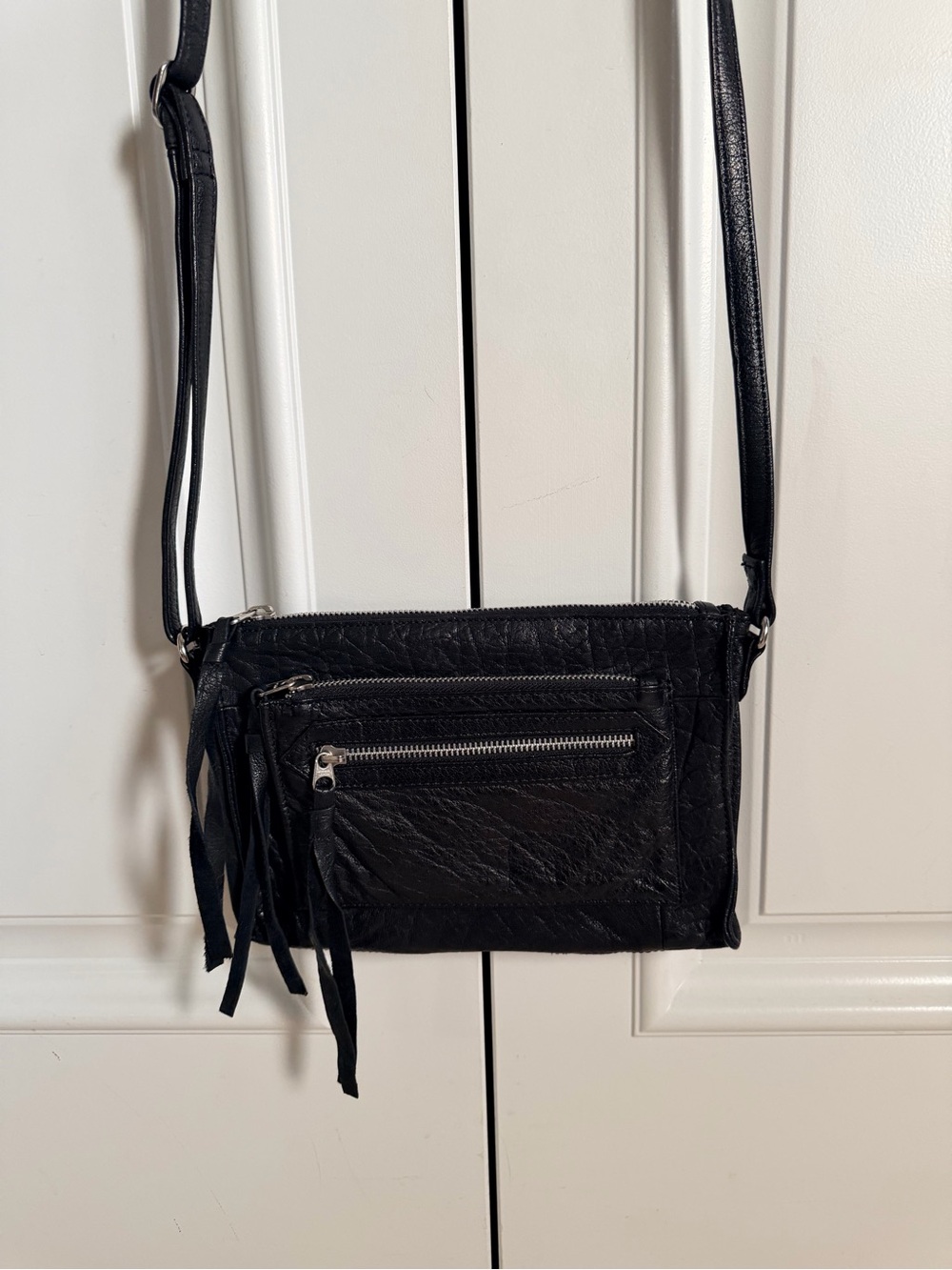 Sleek Black Leather Crossbody Bag with Fringe Accent